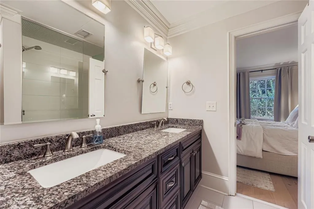 Ensuite bathroom with a shower stall, double vanity, and crown molding Ensuite bathroom with a shower stall, double vanity, and crown molding