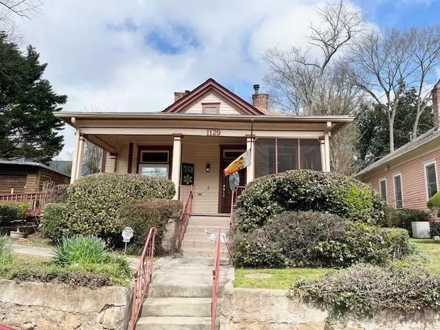 View of front facade with a chimney and covered porch