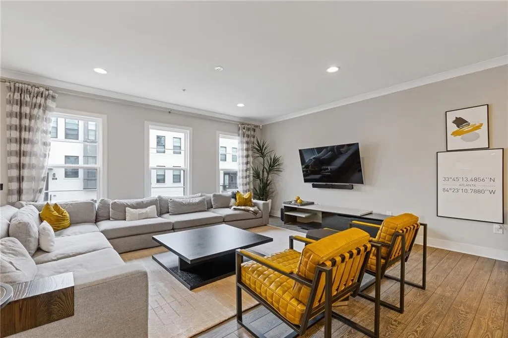 Living room with hardwood / wood-style flooring, recessed lighting, and ornamental molding