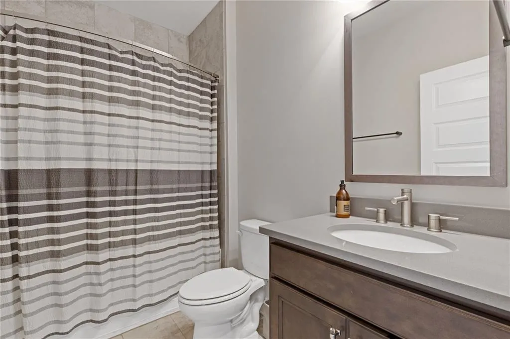 Bathroom with vanity, curtained shower, and light tile patterned floors