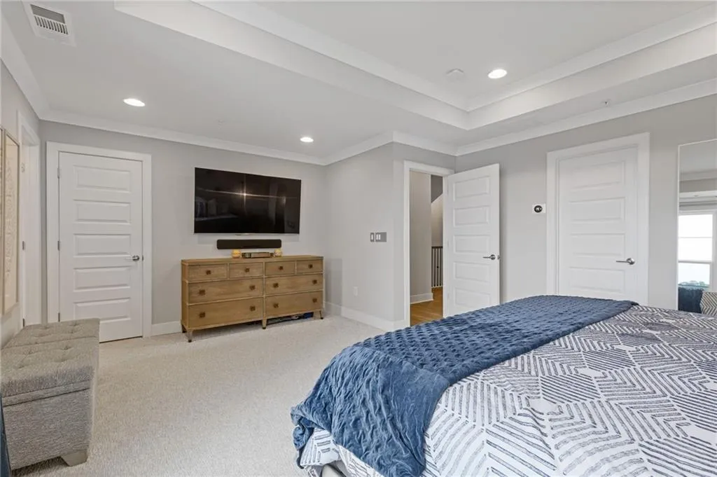 Bedroom with light colored carpet, ornamental molding, and recessed lighting