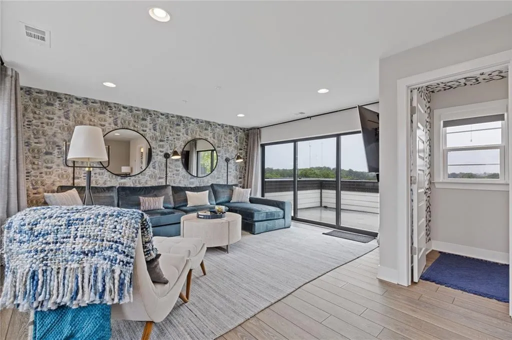 Bedroom with an accent wall, access to outside, light wood finished floors, multiple windows, and recessed lighting