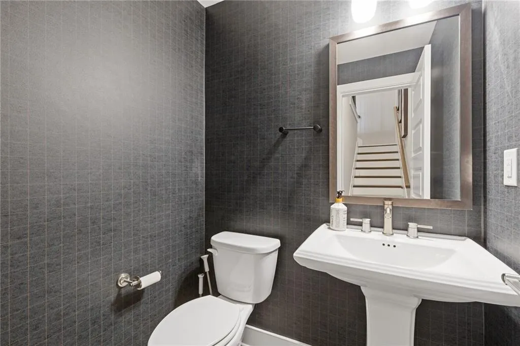 Bathroom with toilet and tile walls