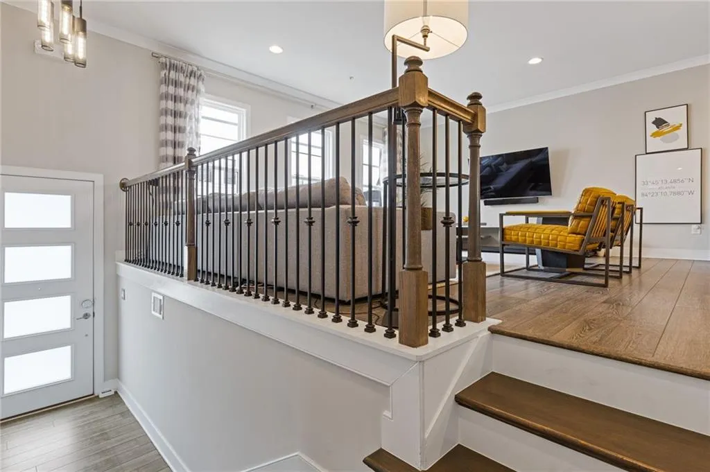 Stairs featuring wood finished floors, crown molding, and recessed lighting