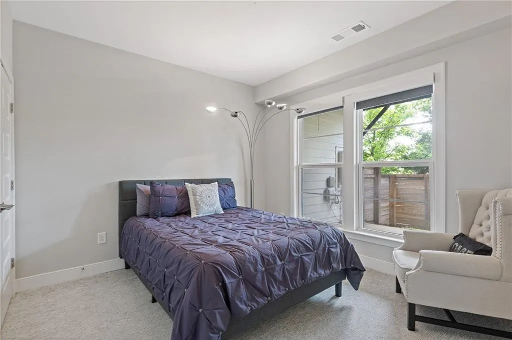 Bedroom featuring light carpet and baseboards