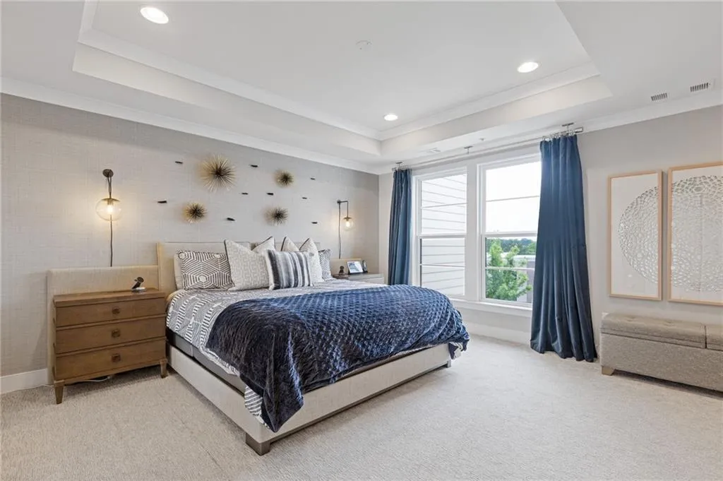 Bedroom with crown molding, light colored carpet, recessed lighting, and a tray ceiling