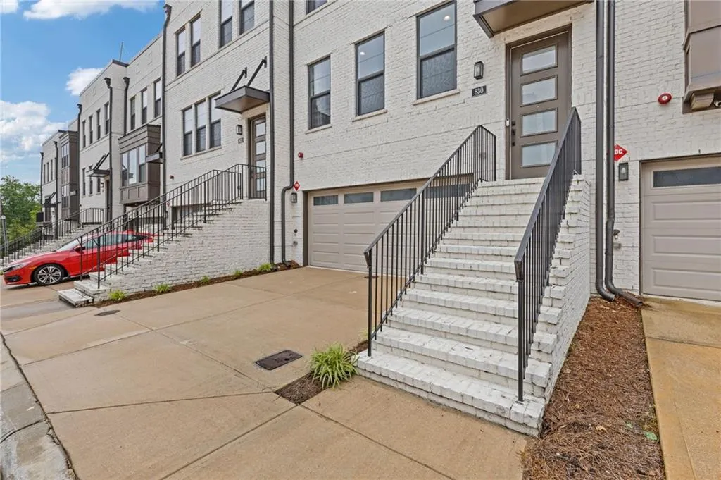 Property entrance with an attached garage, concrete driveway, and brick siding