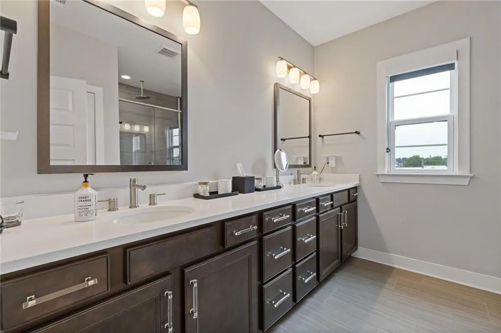 Full bathroom featuring double vanity and a shower stall