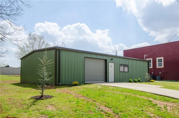 View of outdoor structure featuring concrete driveway