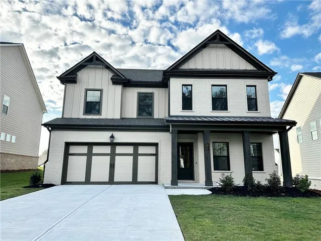 View of front of property with a garage and a front yard