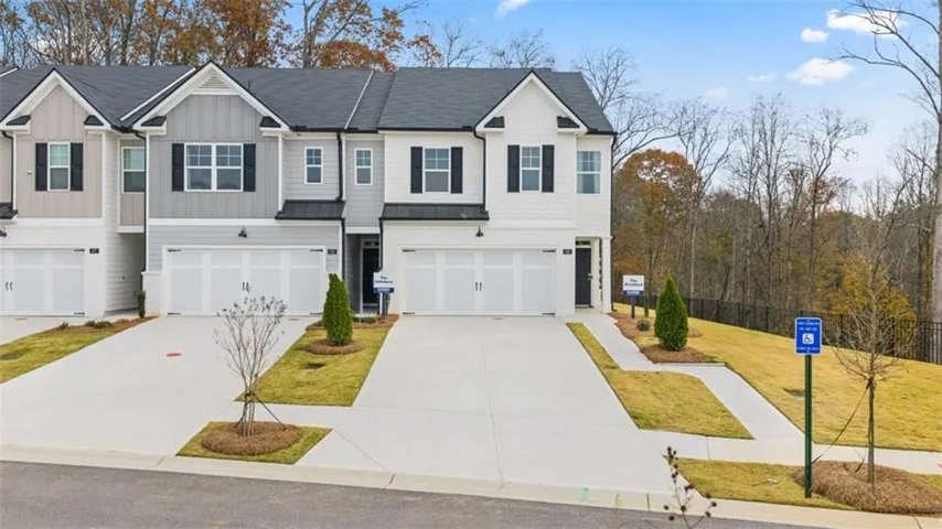 View of front of home featuring a garage, concrete driveway, board and batten siding, a shingled roof, and a front yard