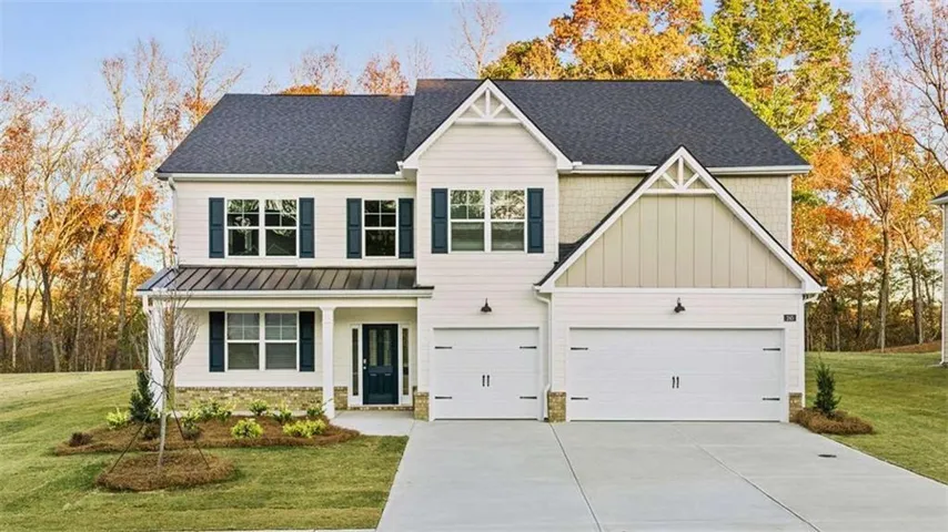 Two-story home with a dark shingle roof, light-colored siding, and a two-car garage