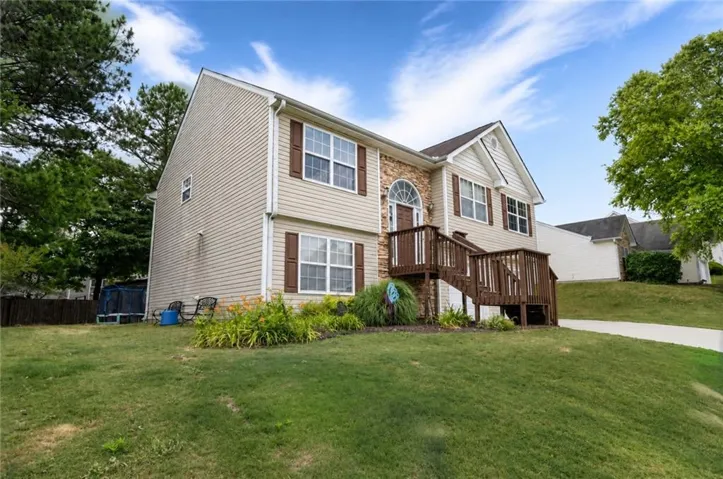 Split-level residence featuring vinyl siding and stone accents