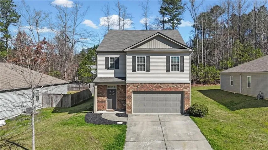 Two-story residence featuring a brick and siding facade with a gabled roof