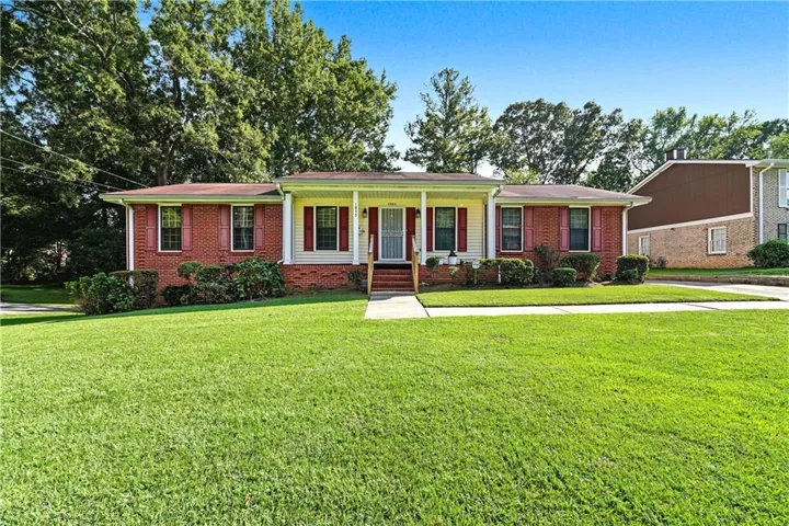 Brick and siding exterior with red window shutters