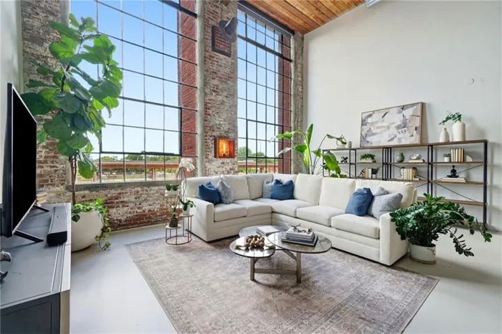 Spacious living area featuring exposed brick accents and industrial-style window framing