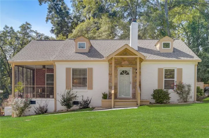 White brick exterior with a screened porch, dormer windows, a covered front entry, and a stone-clad chimney