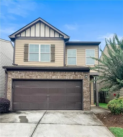Two-story residence featuring a prominent two-car garage with a paneled door