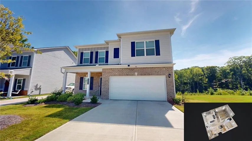 Two-story residence featuring a brick facade, covered entry, attached garage, and a concrete driveway