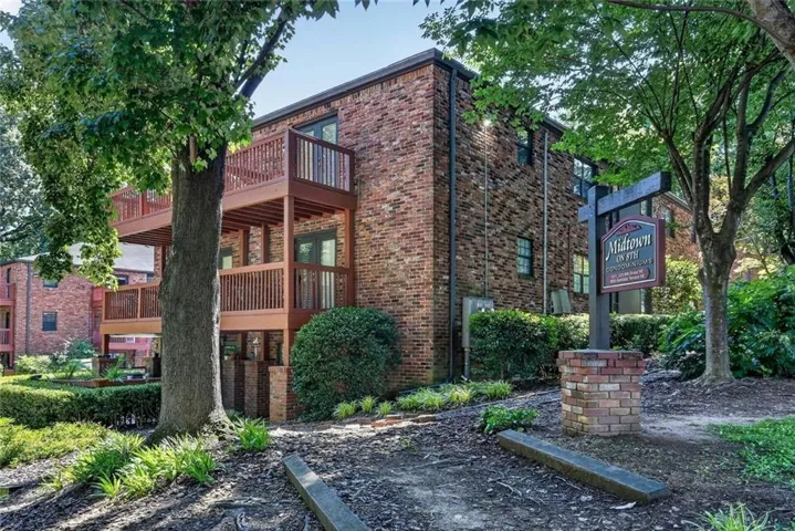 Brick residential building featuring two levels of private balconies with dark wood railings