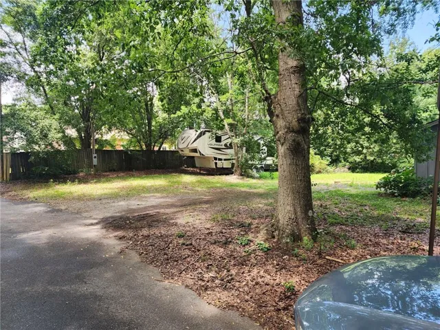 Wood privacy fence enclosing a grassed area with mature trees