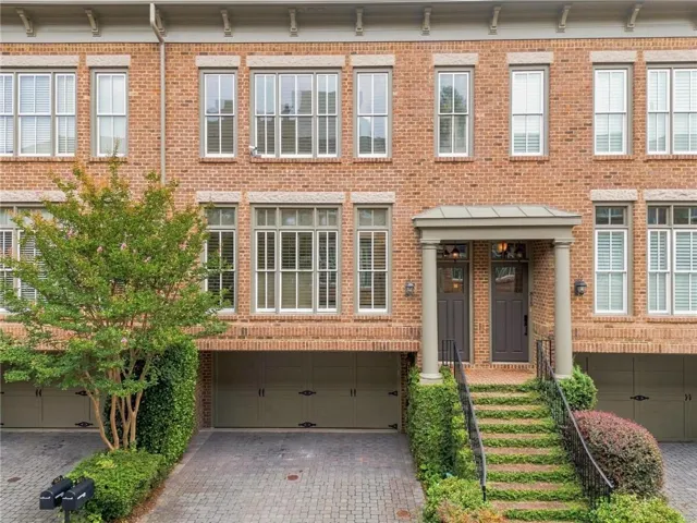 Brick exterior with architectural details, columned entry, and a covered porch