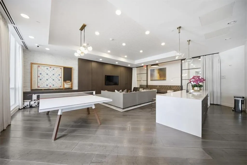 Game room with a raised ceiling and recessed lighting