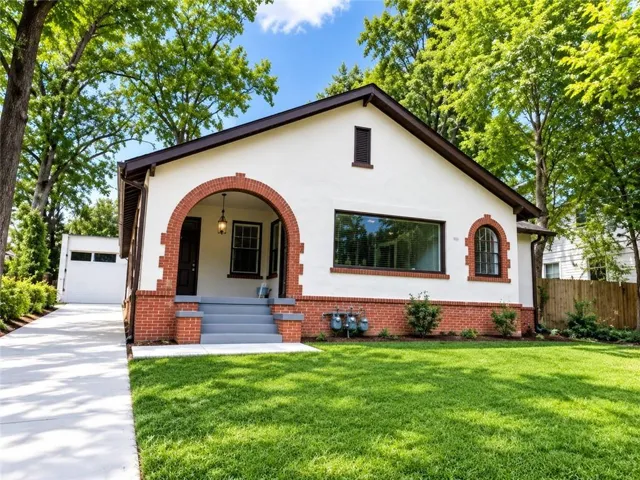 This charming Tudor-inspired bungalow offers exceptional curb appeal with light stucco walls accented by warm red brick detailing, exposed trim, and a prominent arched front entryway.  Brand new driveway and parking area in back.