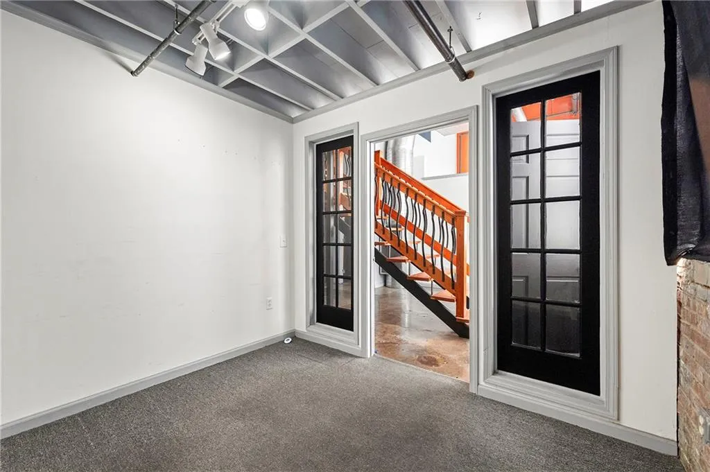 Unfurnished room with stairway and carpet floors