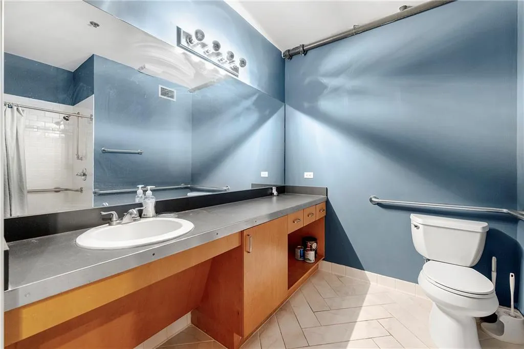 Bathroom with light tile patterned floors, vanity, and a shower with shower curtain