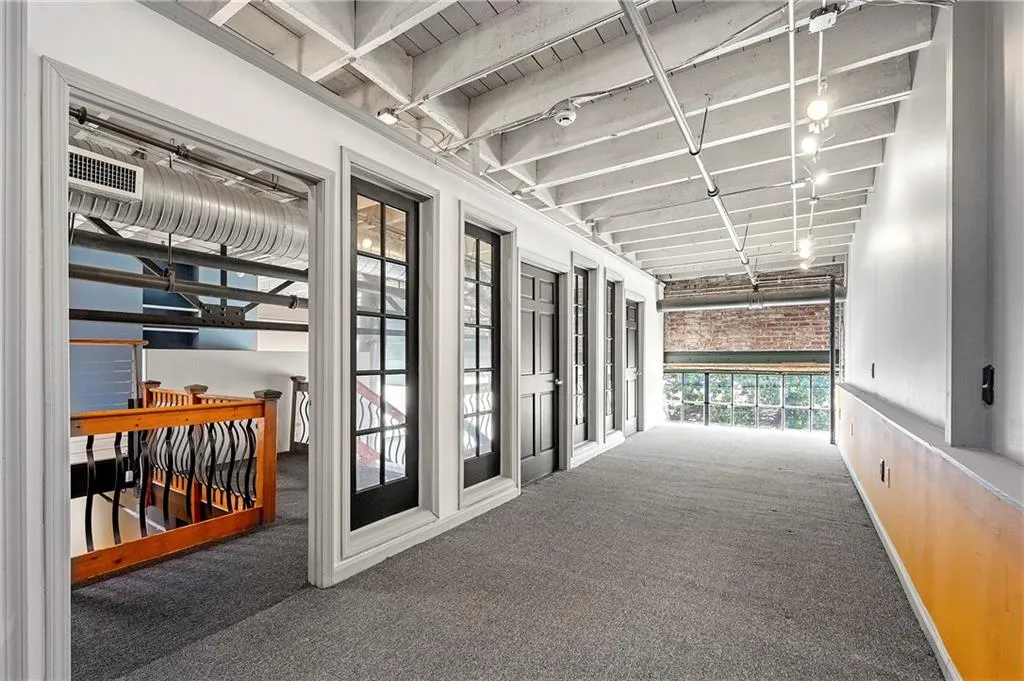 Hall featuring carpet floors and a wooden ceiling with exposed beams