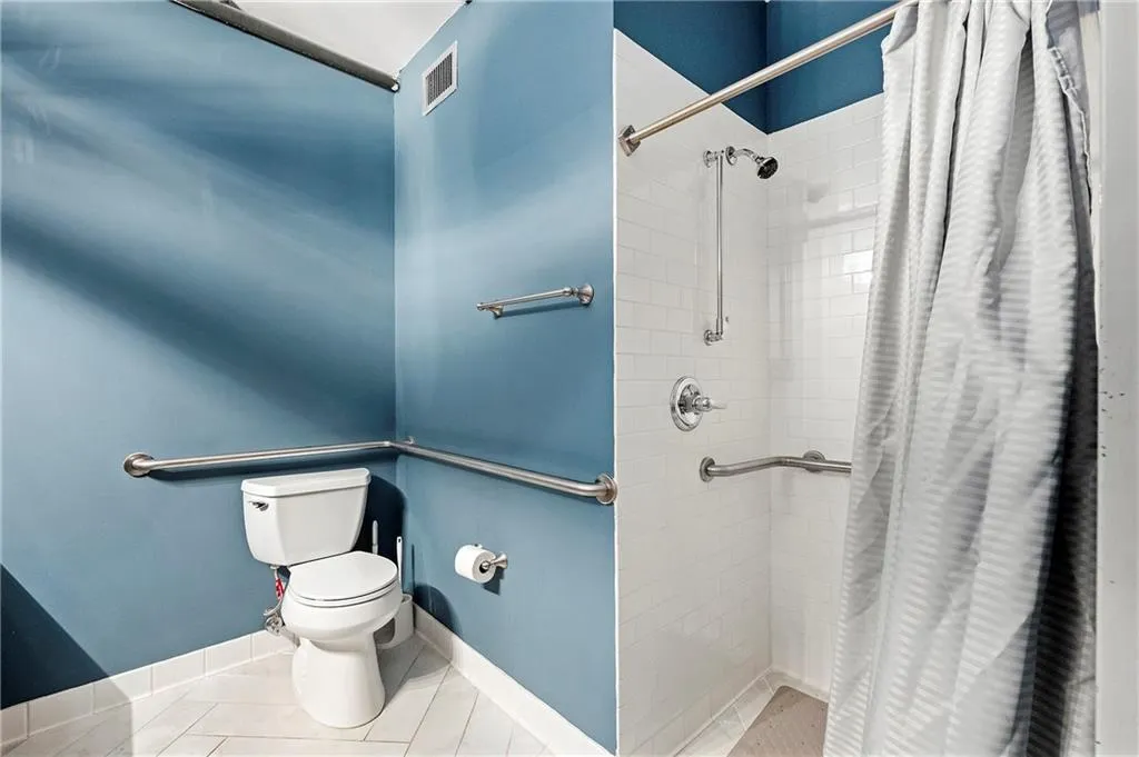 Full bath with a shower stall and tile patterned floors