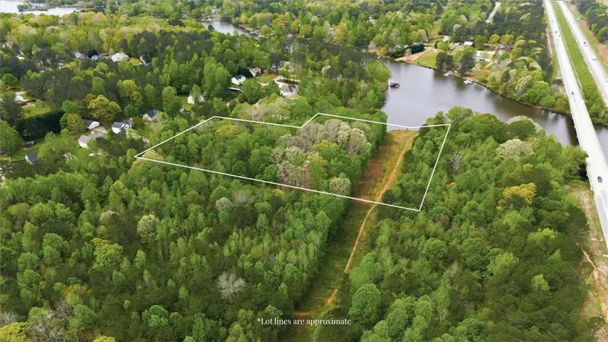 Wooded lot with visible lot lines, surrounded by mature trees