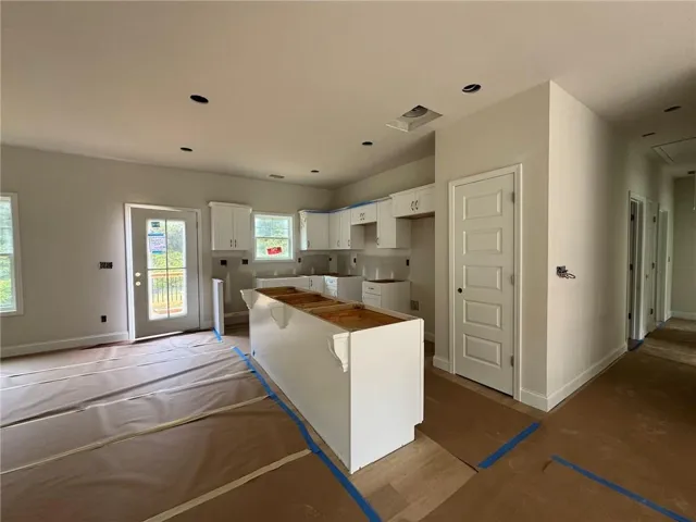Open-concept kitchen with white shaker-style cabinetry, a kitchen island, and recessed lighting