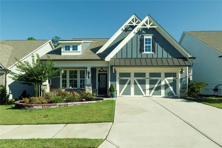 Welcome home to this beautiful Craftsman-style home with an exterior of board and batten siding, stone accents, and a metal roof accent over the garage