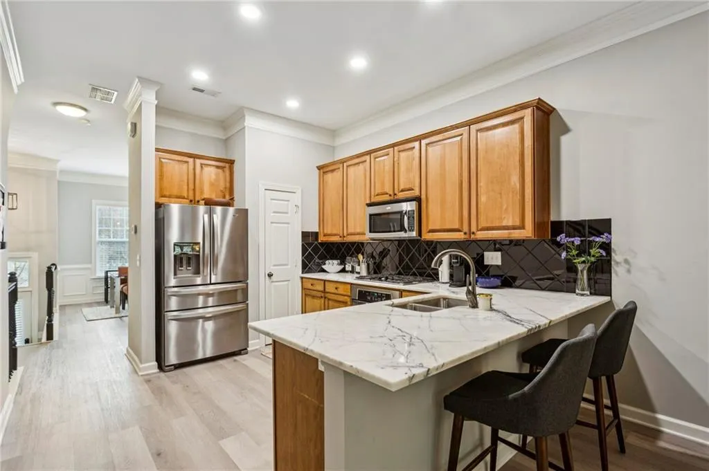 Open floor plan with marble countertops and peninsula bar that flow into a cozy living area.