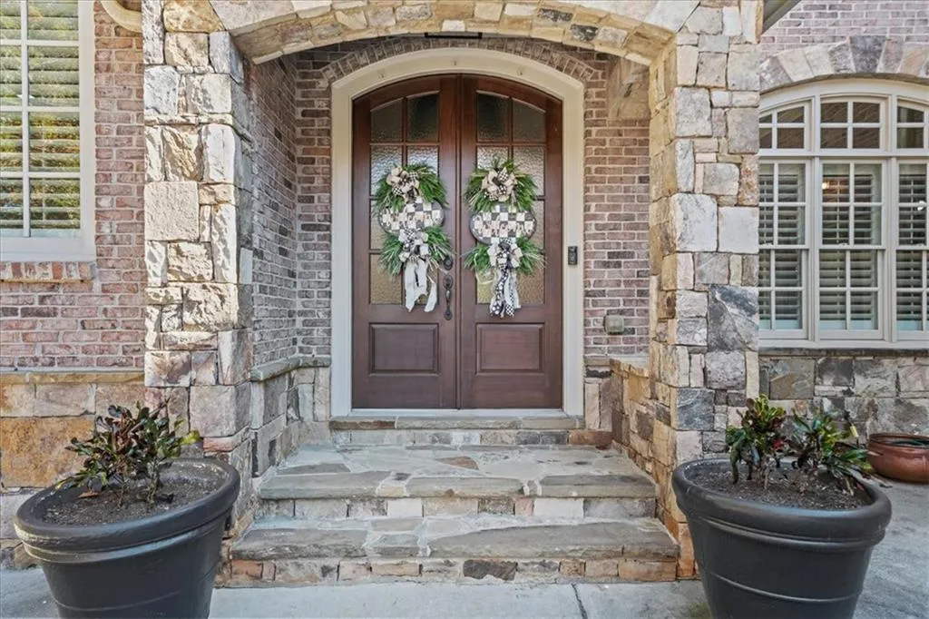 Doorway to property featuring brick siding and stone siding