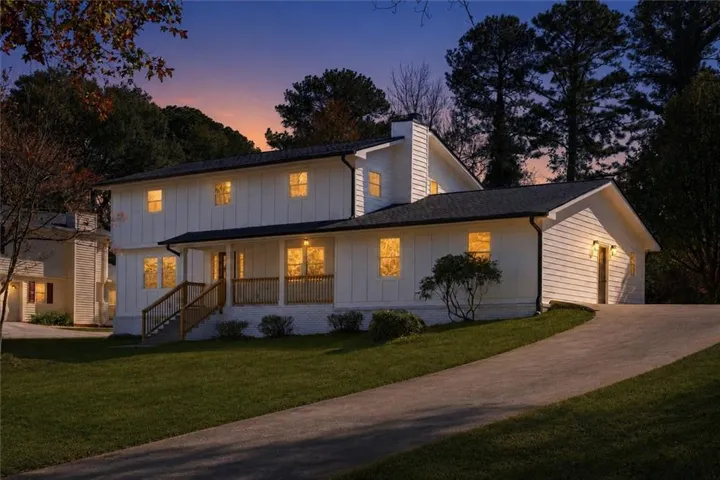 Two-story residence featuring white board-and-batten siding with a dark roof