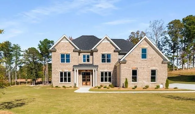 View of front of property with a front yard, brick siding, and french doors