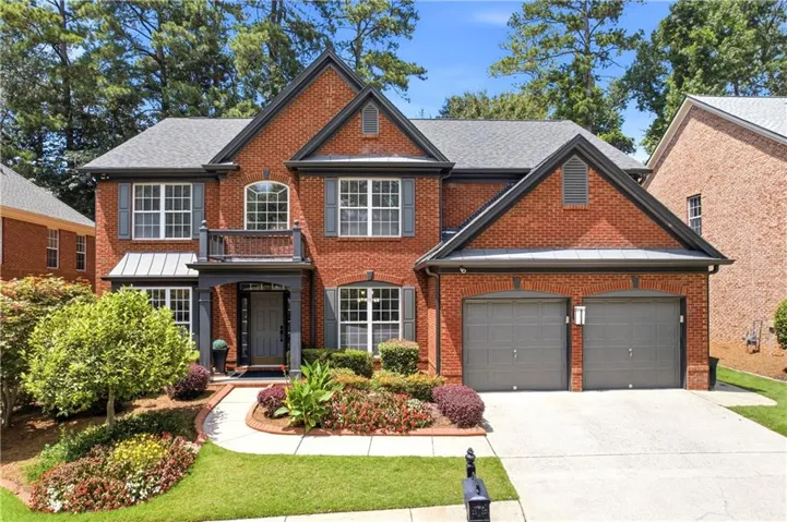 Traditional brick exterior with a gray shingle roof, dark gray trim, and a two-car garage