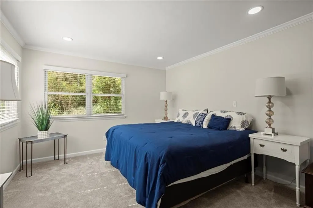 Bedroom #3 on main level with multiple windows and crown molding.  This bedroom is an oversized bedroom and can be used in multiple ways.