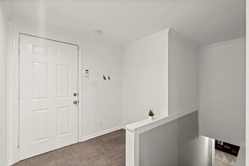 Hallway featuring crown molding.  This is a great space for a cubby!  As you enter from the garage to leave shoes, book bags, etc.