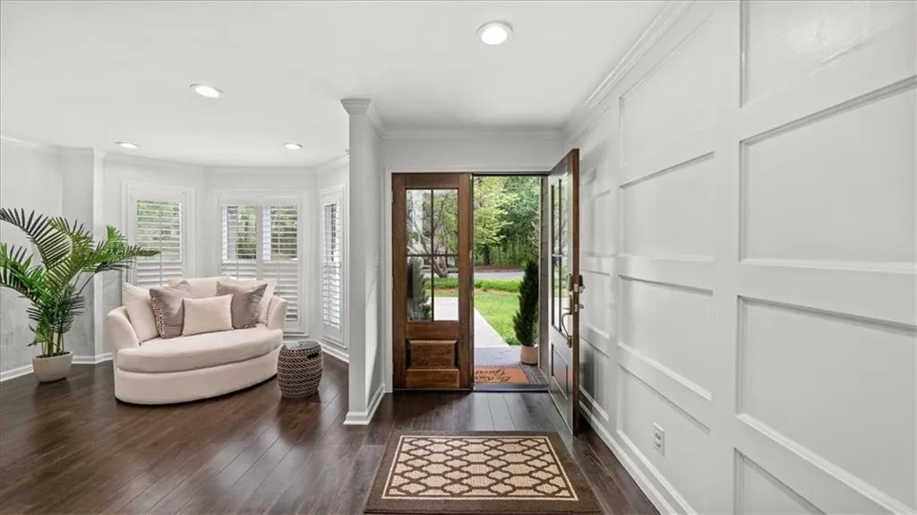 Foyer featuring plenty of natural light, hardwood floors, and front door with glass panels