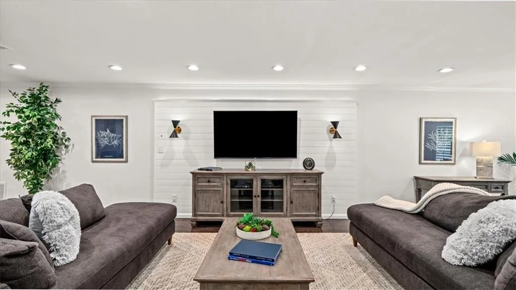 Family room with ornamental molding, columns and recessed lighting throughout.
