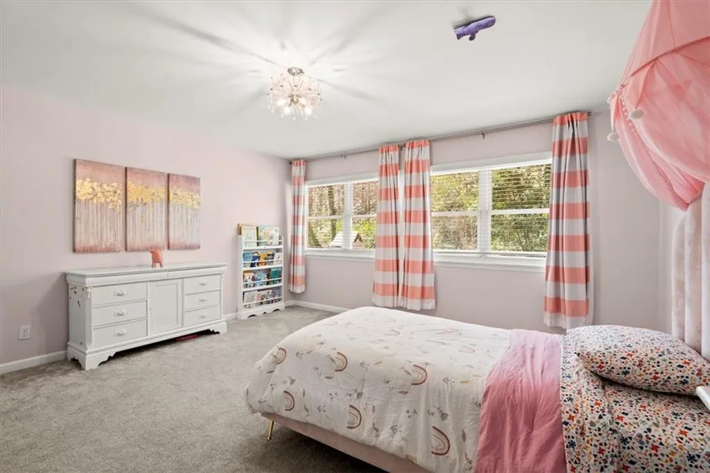 Bedroom #4 on main level with chandelier, lots of natural light you will find in this space.