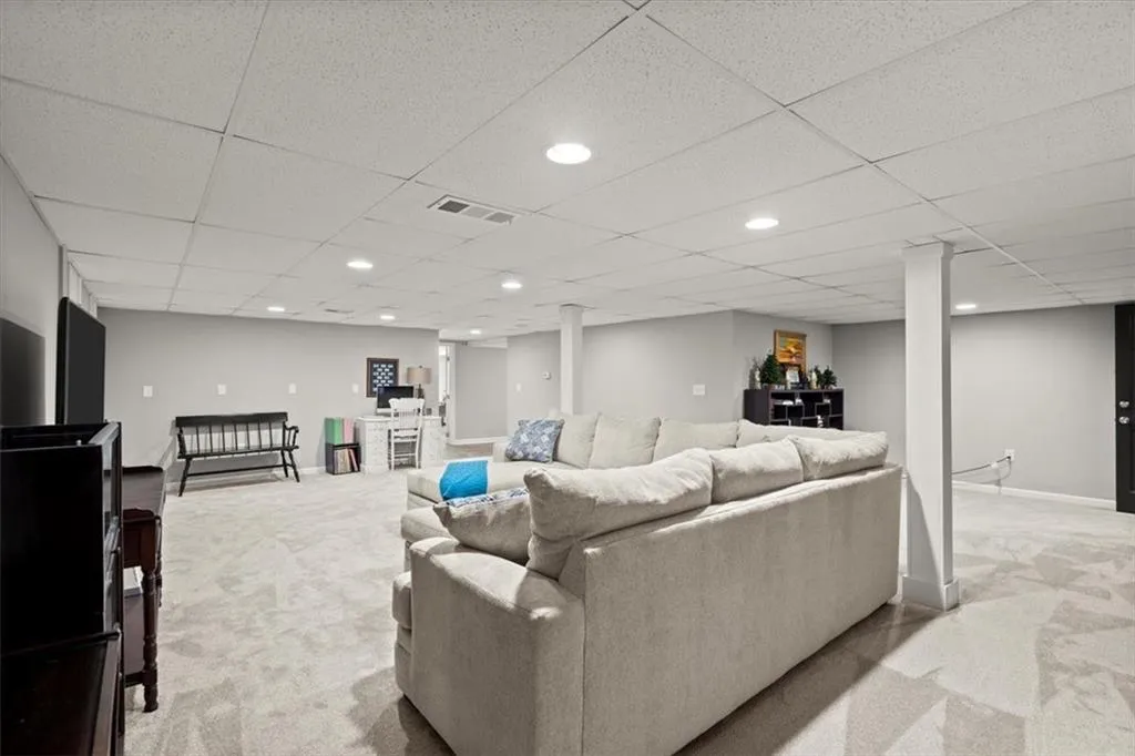 Basement living room featuring decorative columns and plenty of space to have as a 2nd family room gathering, au pare or in-law suite.