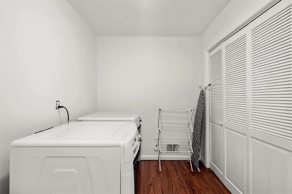 Laundry area featuring washer and dryer and hardwood flooring on main level.
