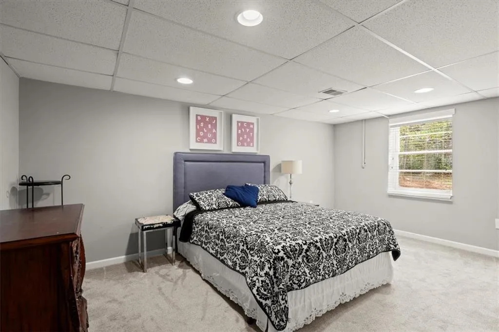 Bedroom #5 located on the terrace or basement level of the home.  Features include new carpeting, window and closet.