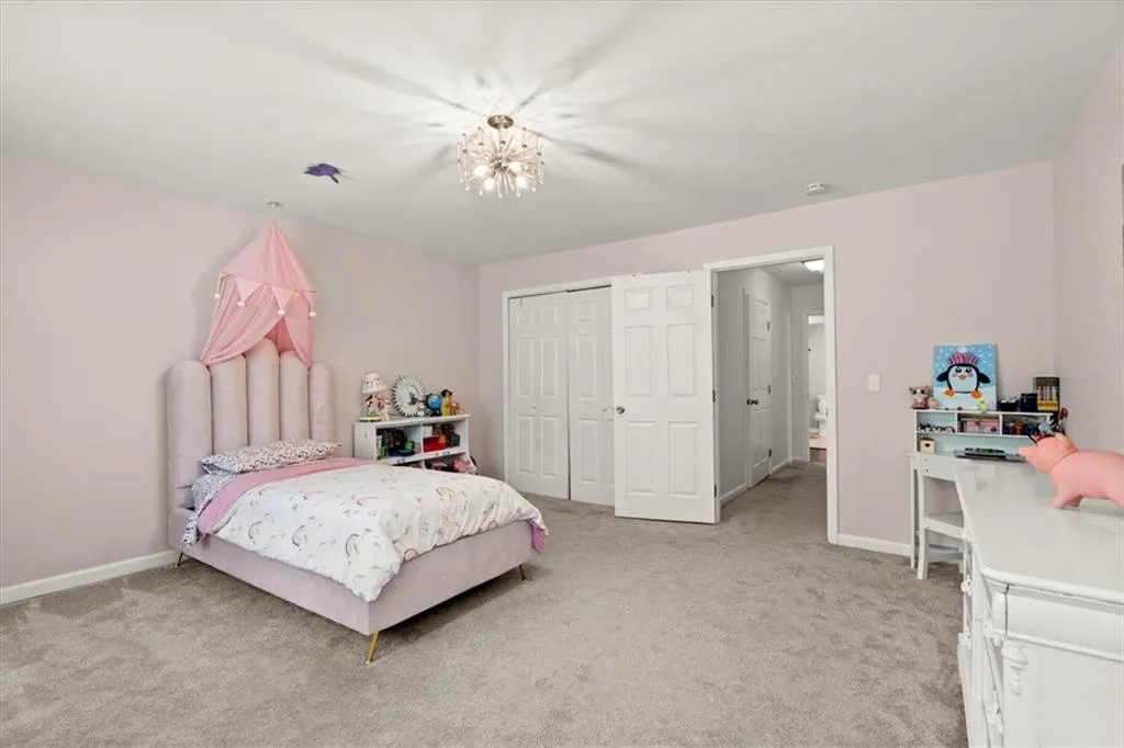 Bedroom #4 on main level with a closet and an inviting chandelier.