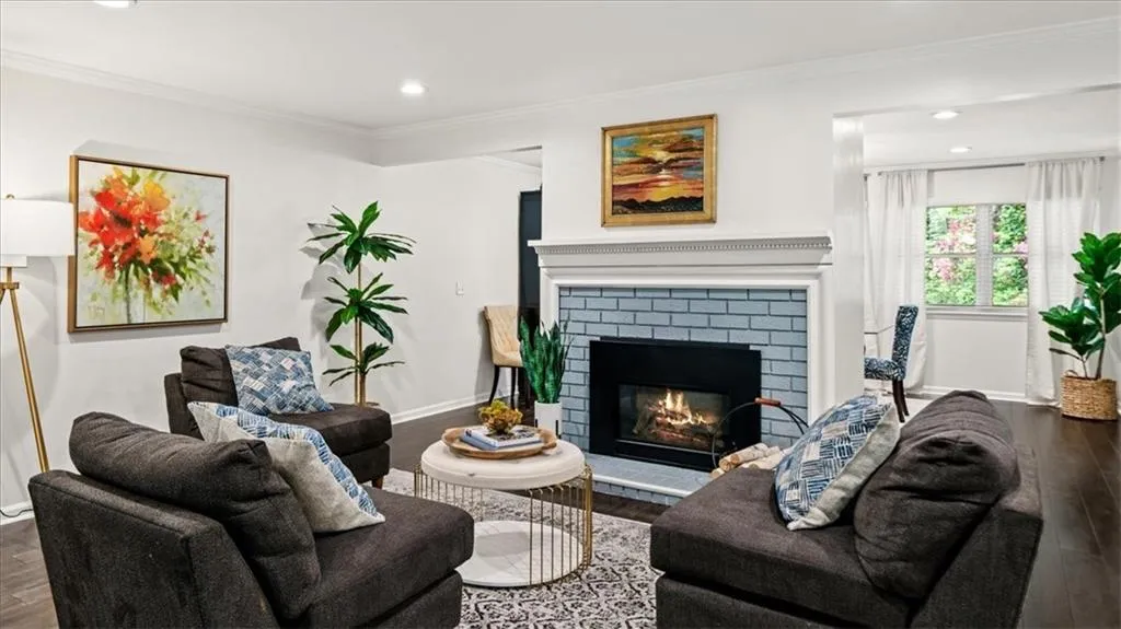 Living room with ornamental molding, brick fireplace and hardwood flooring